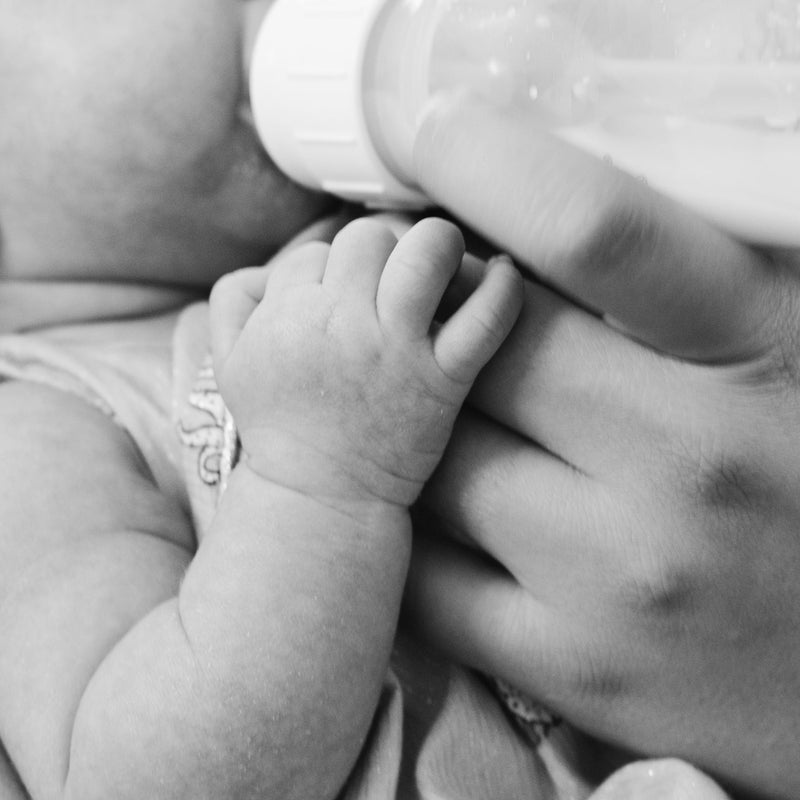 Judes Baby wird gefüttert Flaschenkind